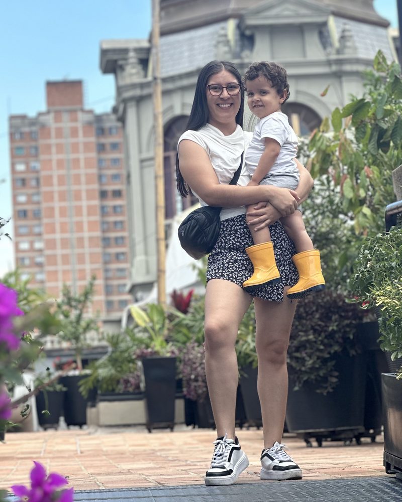 Nati, mamá y creadora de Echa Cuento, con su hijo en brazos al aire libre